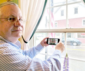 Chuck Benton demonstrates his BoundARy Viewer app at S. Fernald’s Country Store in downtown Damariscotta on June 7. The red lines mark the boundaries of the property across the street. (Haley Bascom photo)