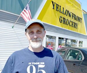 Yellowfront Grocery owner Jeff Pierce stands in front of the store, which is celebrating its 95th anniversary. His shirt - a gift from a customer - reads â€œIt took me 95 years to look this good.â€ (Maia Zewert photo)