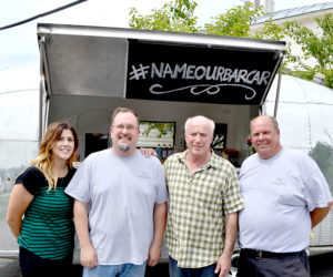 From left: Leslie Lorentzen, Jed Weiss, Warren Storch, and Todd Maurer stand in front of Stone Cove Catering's new addition, a 1963 Airstream GlobeTrotter "bar car." (Maia Zewert photo)