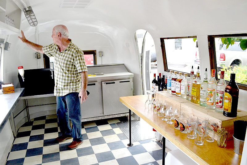 The Walpole Barn owner Warren Storch inspects the interior of a 1963 Airstream GlobeTrotter that Stone Cove Catering recently renovated into a bar car. (Maia Zewert photo)