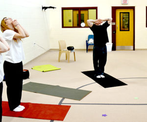 From left: Mary Catherine Wilson, Felichia Glidden, Ben Foster, and Jason DuRoss participate in a breathing exercise during a yoga class at Two Bridges Regional Jail in Wiscasset on Thursday, July 14. (Abigail Adams photo)