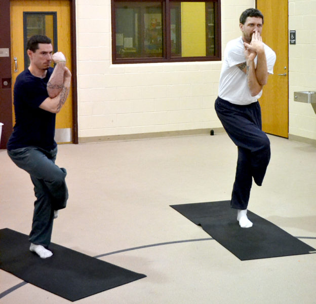 Ben Foster (left) and Jason DuRoss go into the eagle pose during a yoga class at Two Bridges Regional Jail on Thursday, July 14. (Abigail Adams photo)