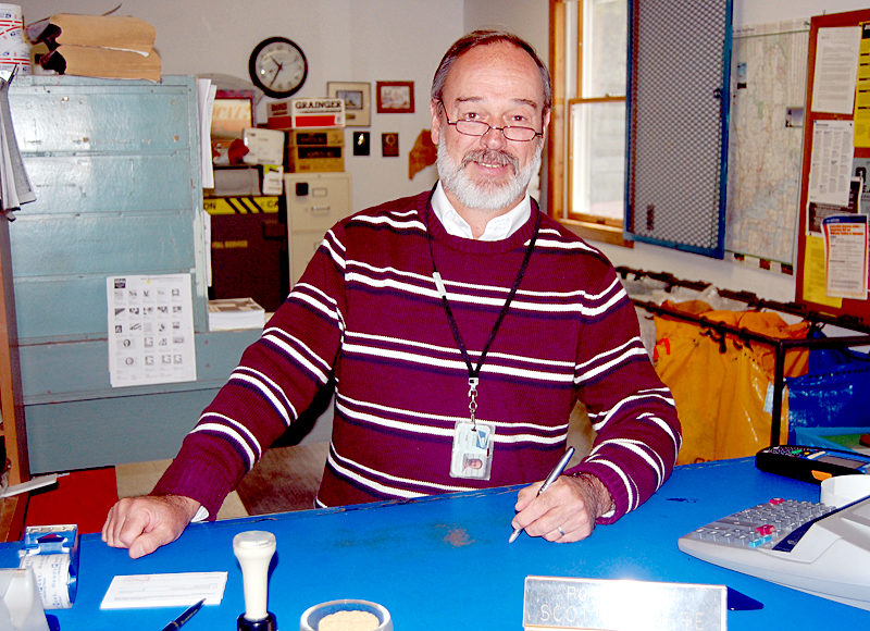 Then-Bremen Postmaster Scott Giguere stands behind the counter at the Bremen post office in May 2012, shortly before his retirement. (J.W. Oliver photo, LCN file)
