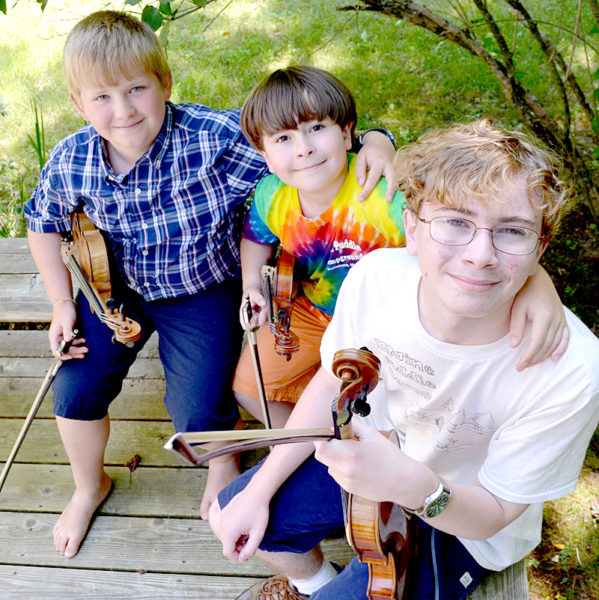 From left: Owen Kennedy, Benjamin Rosenthal, and Joshua Rosenthal make up the fiddling trio Fiddlocity². The boys competed in the East Benton Fiddlers Convention and Contest on Sunday, July 30, with Joshua winning first place, Benjamin taking second, and Owen third. (Maia Zewert photo)