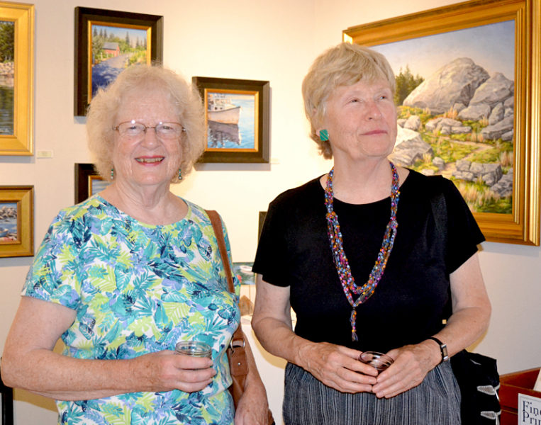 Bristol artist Judy Nixon (left) and artist Jane Bowman, of New Harbor, sip wine and take in the profusion of art at the Saturday, Aug. 6 opening reception for the "Rock 'n' Wave" art show at the Kefauver Studio & Gallery in Damariscotta. Both Nixon and Bowman have artwork in the current show, which runs through Aug. 28. (Christine LaPado-Breglia photo)