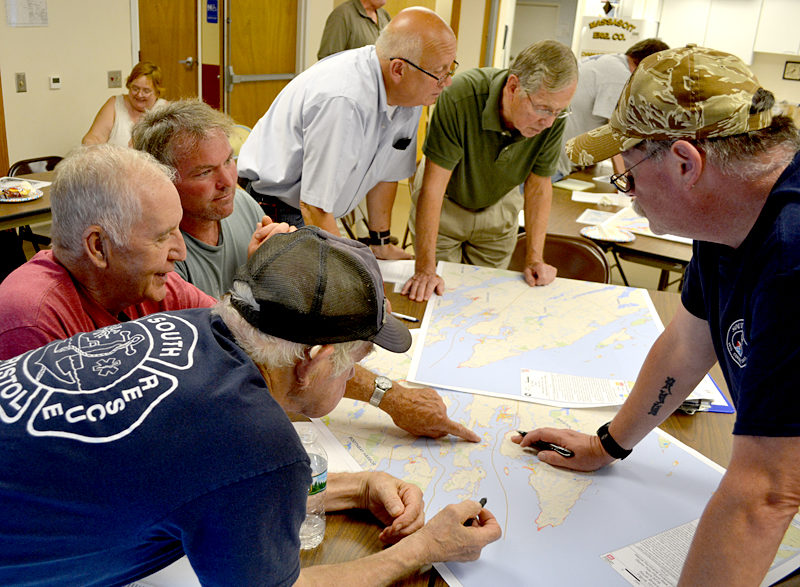 Central Lincoln County officials look at maps of the area during a tabletop exercise at the Damariscotta Fire Department on Thursday, Aug. 18. Clockwise from bottom left: South Bristol Assistant Fire Chief Gunnar Gundersen, South Bristol Selectman Chester Rice, South Bristol Assistant Fire Chief John Seiders, Bristol Fire Chief Paul Leeman Jr., Bristol Selectman Harry Lowd, and South Bristol Fire Chief Mark Carrothers. (Maia Zewert photo)