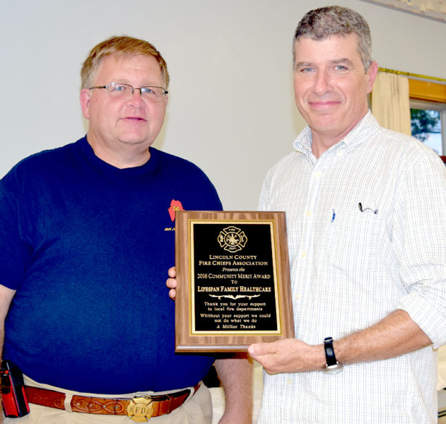 Lincoln County Fire Chiefs Association Vice President Walter Morris (left) presents the association's Community Merit Award for Lifespan Family Healthcare to Dr. Michael Clark. (J.W. Oliver photo)