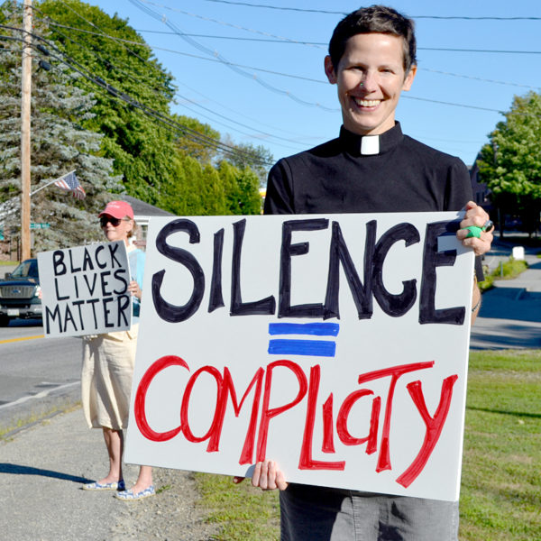 The Rev. Erika Hewitt, of the Midcoast Unitarian Universalist Fellowship, and Julia Fitz-Randolph (left) hold signs during a vigil to protest racism at Veterans Memorial Park in Newcastle on Monday, Aug. 22. (Maia Zewert photo)