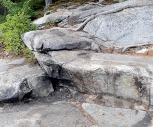 According to Maine Department of Environmental Protection Director of Communications David Madore, the cleanup of tar or a tar-like substance on the shore of Peter's Pond was succesful, with only a slight stain remaining on the rocks. (Paula Roberts photo)