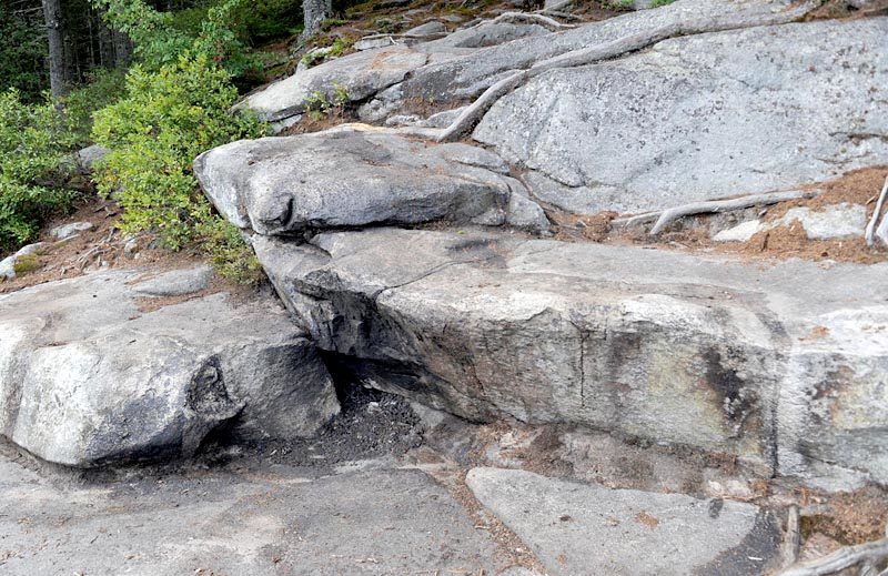 According to Maine Department of Environmental Protection Director of Communications David Madore, the cleanup of tar or a tar-like substance on the shore of Peter's Pond was succesful, with only a slight stain remaining on the rocks. (Paula Roberts photo)