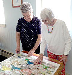 Hardest puzzle evah! Hodgdon Green residents Patty Hagar (left) and Lilah Blechman added the final pieces to their 1,000-piece puzzle featuring teacups of many patterns. Both worked tirelessly to complete the difficult puzzle in two months.