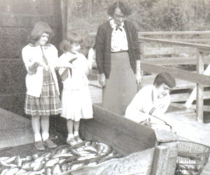 Since 1807, widows in Newcastle and Nobleboro have been entitiled to a share (now two bushels) of alewives in the spring run. Here, in 1955, a widow and her two daughters are receiving their share. (Photo courtesy Newcastle Historical Society, Janice McGrath collection)