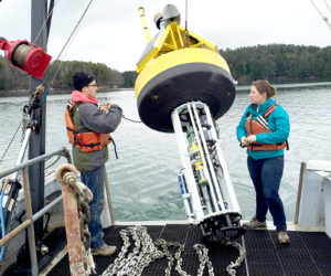 Matthew Gray and Katie Coupland deploy a buoy. Gray is a postdoctoral research associate and Coupland is a doctoral candidate in oceanography; both are based at the University of Maine Darling Marine Center in Walpole.