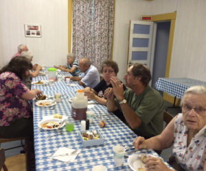 Community members enjoy a potluck supper before the 63 card game.