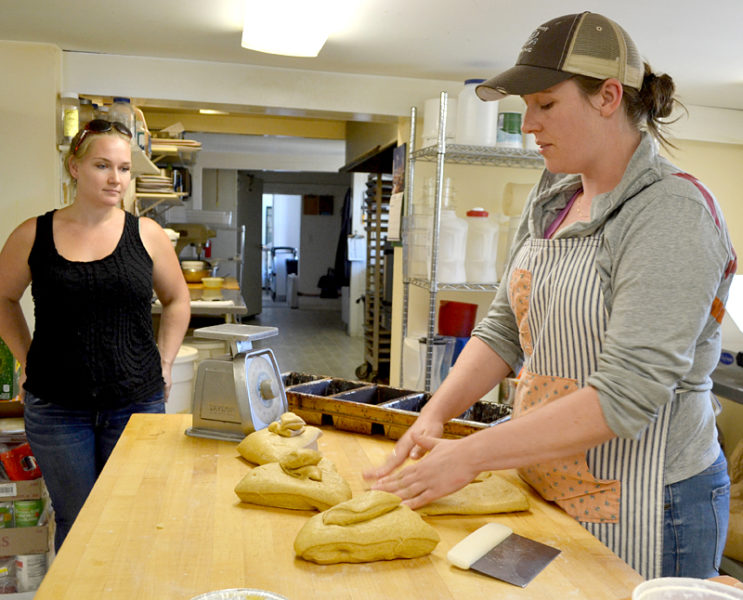 Barn Door Baking Company baker and co-owner Andrea "Annie" Leck kneads bread dough as Crystal Berg, the business's office manager and co-owner, looks on in the company's Damariscotta kitchen on Monday, Sept. 12. (Maia Zewert photo)