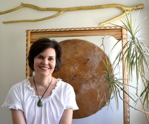 Emily Sabino, of Newcastle, offers intuitive readings and healing in her 13 Pleasant St. home. During a session, Sabino uses various techniques and tools to assist with the healing process, including the large drum behind her. (Maia Zewert photo)