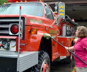 Lincoln Academy sophomore Crystal Miller scrubs a Damariscotta fire truck as part of Lincoln Academy's Sophomore Service Day on Wednesday, Aug. 31. (Maia Zewert photo)