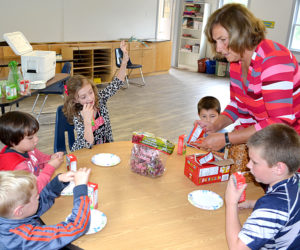 Terry Mitchell, the director of South Bristol Schools new after-school program, serves snacks to the five children who attended the program Tuesday, Sept. 6. Clockwise from bottom left: South Bristol kindergartners Sam Kress and Autumn Cantillo, third-grader Maya Redonnett, kindergartner Robert Bennett, and third-grader Blake Gamage. (Maia Zewert photo)