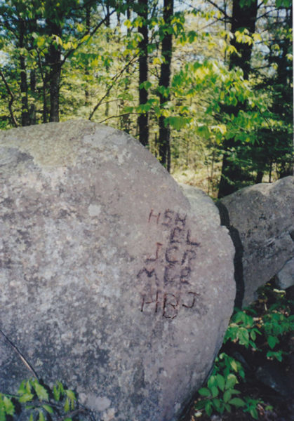 To get an effective photo, we took a black marking pen and carefully traced out the initials on this split rock as best we could. (Arlene Cole photo)