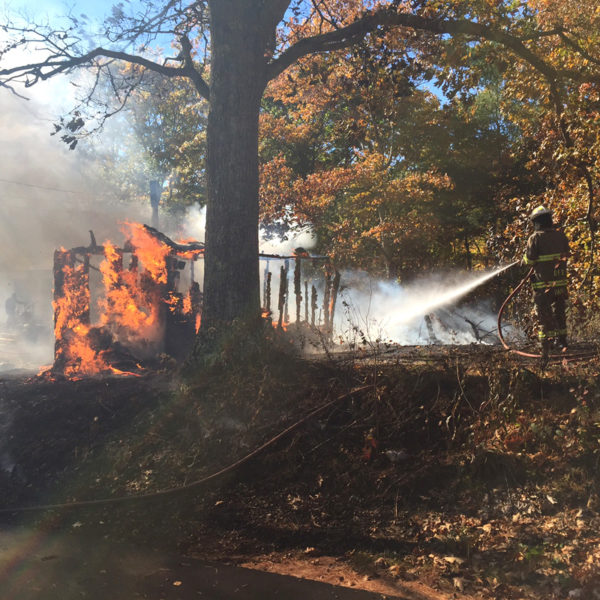 A Damariscotta firefighter works at the scene of a structure fire on North Dyer Neck Road in Newcastle. (Maia Zewert photo)