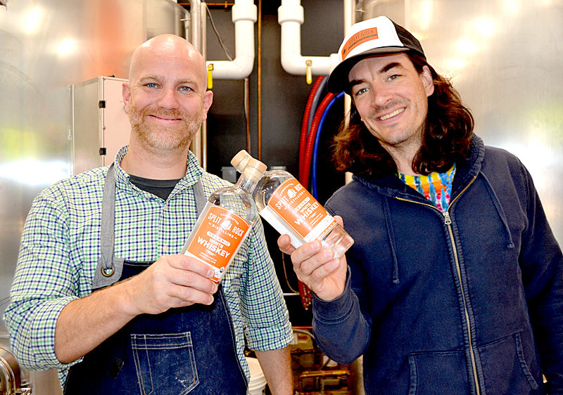 Split Rock Distilling co-founders Matt Page (left) and Topher Mallory display bottles of white whiskey, the newest spirit in the organic distillery's line. The Newcastle business will celebrate its grand opening throughout Columbus Day weekend, Oct. 7-9. (Maia Zewert photo)