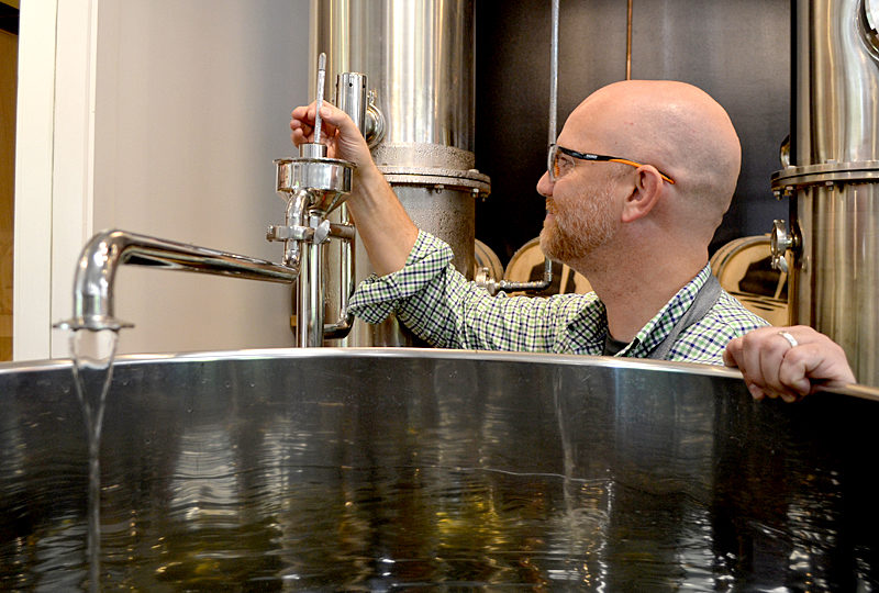 Split Rock Distilling co-founder Matt Page checks the temperature of the still Monday, Oct. 3. (Maia Zewert photo)