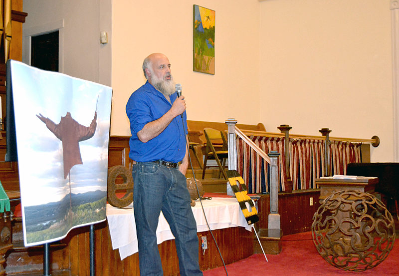 Metal artist Jay Sawyer, a graduate of Medomak Valley High School in Waldoboro, gives a presentation titled "Making New Art from Old Items" as the Waldoborough Historical Society's final program of the year on Wednesday, Oct. 12 at the Broad Bay Congregational United Church of Christ in Waldoboro. He is surrounded by examples of his work, including a large photograph of his metal sculpture "The Maestro;" a yellow-and-black-striped metal sculpture called "Bumble B"; and a 29-inch sphere made of used horseshoes salvaged from a horse farm in Virginia. (Christine LaPado-Breglia photo)