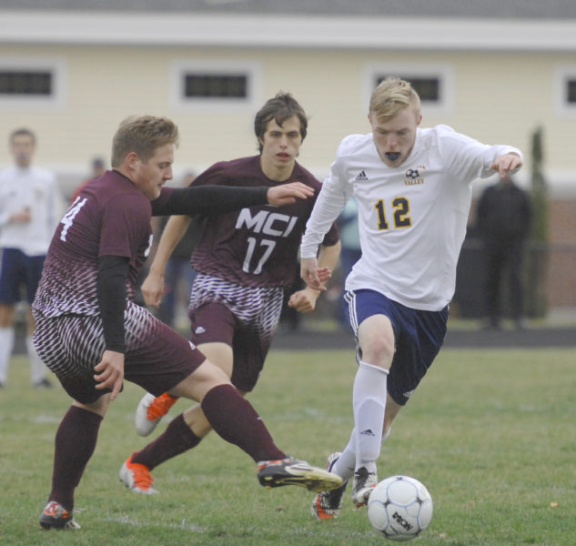 Cale Gee pushes the ball away from two MCI defenders. (Paula Roberts photo)