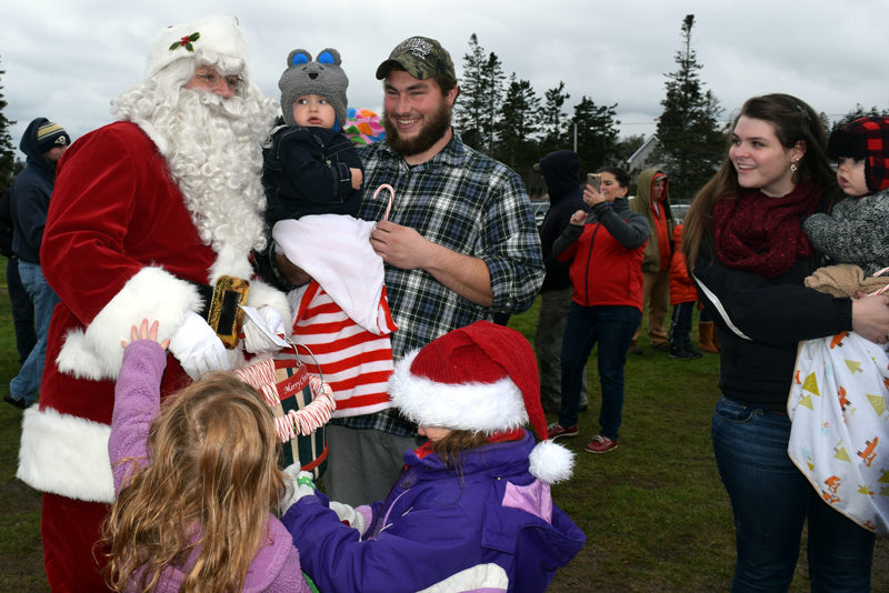 Santa Claus draws curious looks from a couple of babies as other children try to attract his attention during his visit to Pemaquid Point Lighthouse Park on Sunday, Nov. 27. (J.W. Oliver photo)