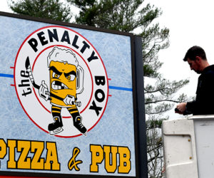 Dave Morgan, of The Sign Store & Flag Center in Auburn, works on the sign for The Penalty Box Pizza & Pub the morning of Tuesday, Nov. 15. The new restaurant in the 436 Main St. space formerly home to Romeo's Pizza will open at 5 p.m., Thursday, Nov. 17. (J.W. Oliver photo)