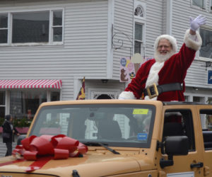 Santa Claus waves to the crowd as he makes his way down Main Street in Damariscotta on Saturday, Nov. 26. (Maia Zewert photo)
