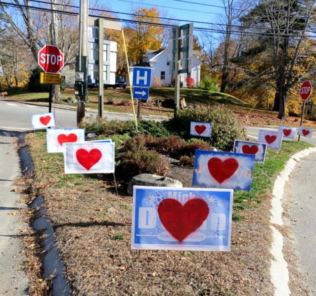 Campaign signs bearing hearts in the traffic island at the intersection of Academy Hill Road, Main Street, and Mills Road in Newcastle the morning of Thursday, Nov. 10. (Photo courtesy Chris Johnson)