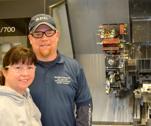 Mike and Paula Cuthbertson stand in front of one of the Specialty Products Co. machines Tuesday, Nov. 29. The Specialty Products Co. plant in Whitefield, which manufactures precision machine parts, will more than double in size in the next year. (Abigail Adams photo)