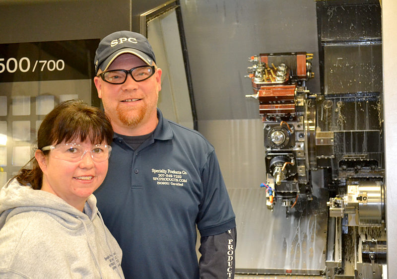 Mike and Paula Cuthbertson stand in front of one of the Specialty Products Co. machines Tuesday, Nov. 29. The Specialty Products Co. plant in Whitefield, which manufactures precision machine parts, will more than double in size in the next year. (Abigail Adams photo)