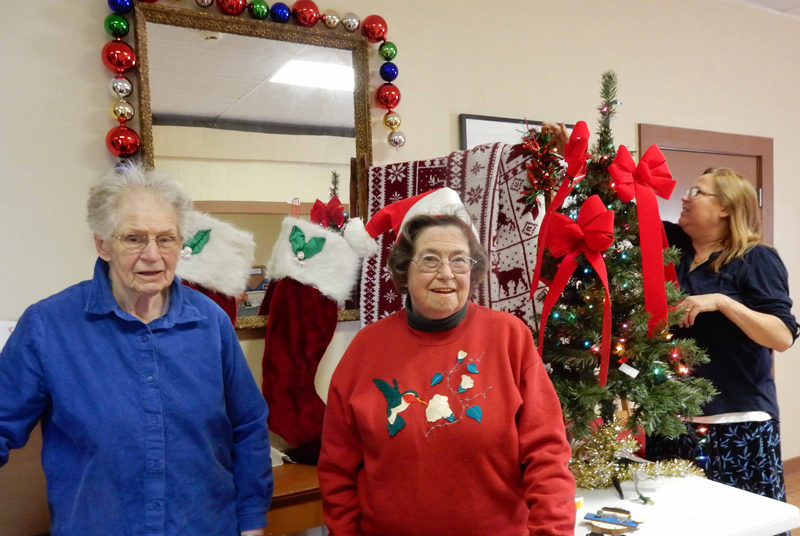 From left: Gwen Swank, Pam Meserve, and Mary Goulette prepare to deck the hall at the Alna Anchor Masonic Lodge.