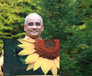 Dr. Rifat Zaidi holds a photo of a sunflower that will be on display at the Miles Campus of LincolnHealth from Saturday, Nov. 26 through Christmas Day. Zaidi's photographs are printed on aluminum, a much more durable medium than paper prints. All funds from the sale of the photographs will go toward building a school for girls in a deeply impoverished area in Pakistan.