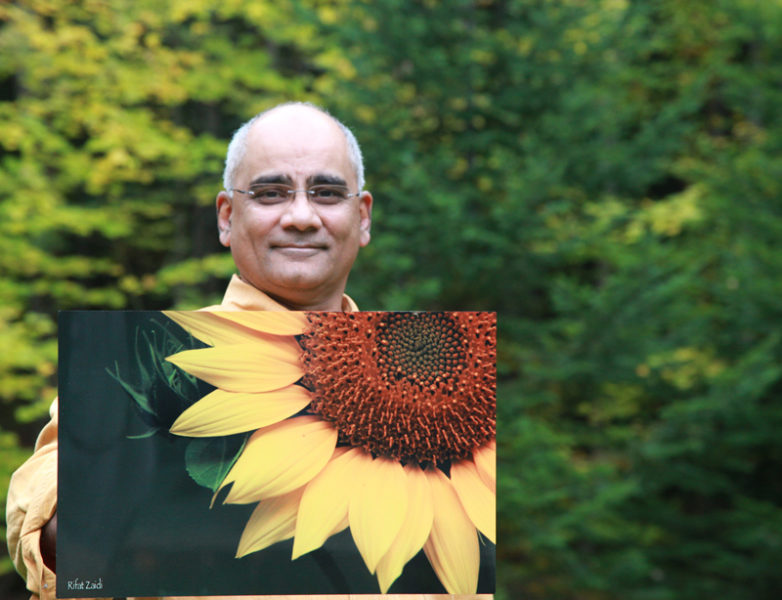 Dr. Rifat Zaidi holds a photo of a sunflower that will be on display at the Miles Campus of LincolnHealth from Saturday, Nov. 26 through Christmas Day. Zaidi's photographs are printed on aluminum, a much more durable medium than paper prints. All funds from the sale of the photographs will go toward building a school for girls in a deeply impoverished area in Pakistan.