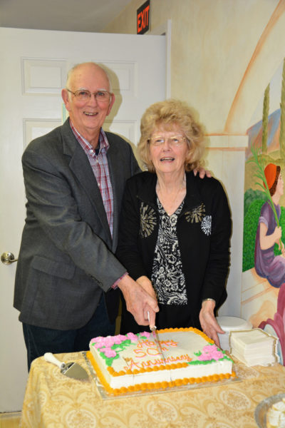 Dana and Rita Simmons cut the cake at their golden wedding anniversary celebration on Dec. 3 at Bremen Union Church, where they were married in a candlelight service 50 years ago. (Photo courtesy Lynn Carlson)