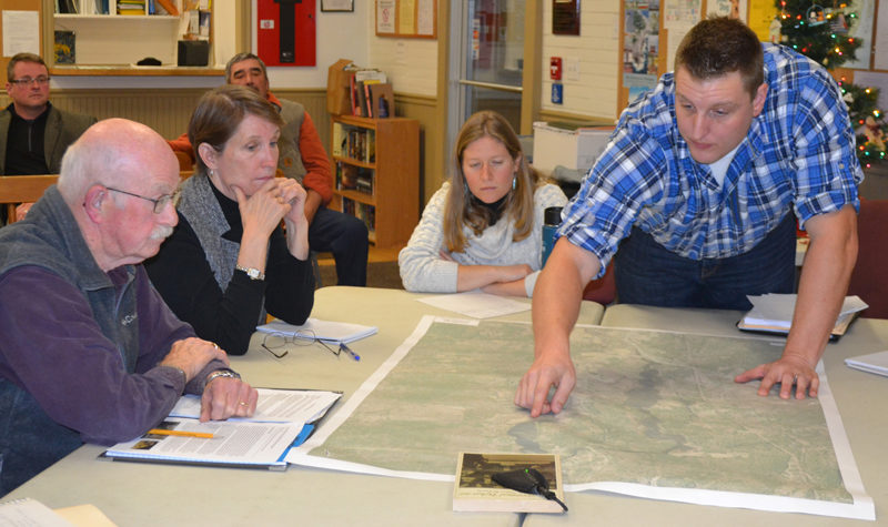 Wright-Pierce engineer Joe McLain points at a map as Bristol Dam Advisory Committee members (from left) Bill Benner, Abby Ingraham, and Claire Enterline look on during a committee meeting Wednesday, Dec. 7. (Maia Zewert photo)