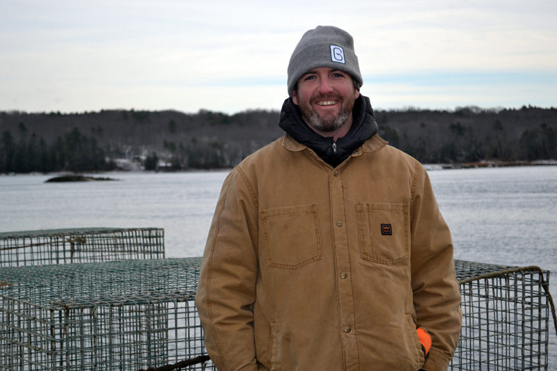 Ryan McPherson, the new owner of Glidden Point Oyster Sea Farm, stands on the dock of 637 River Road, the new headquarters for the business, on Tuesday, Dec. 20. (Abigail Adams photo)