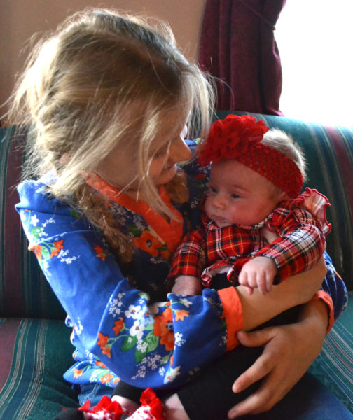 Avalee Brightman-Uhl cradles her 13-week-old sister, Ainsley Merrill. (Maia Zewert photo)