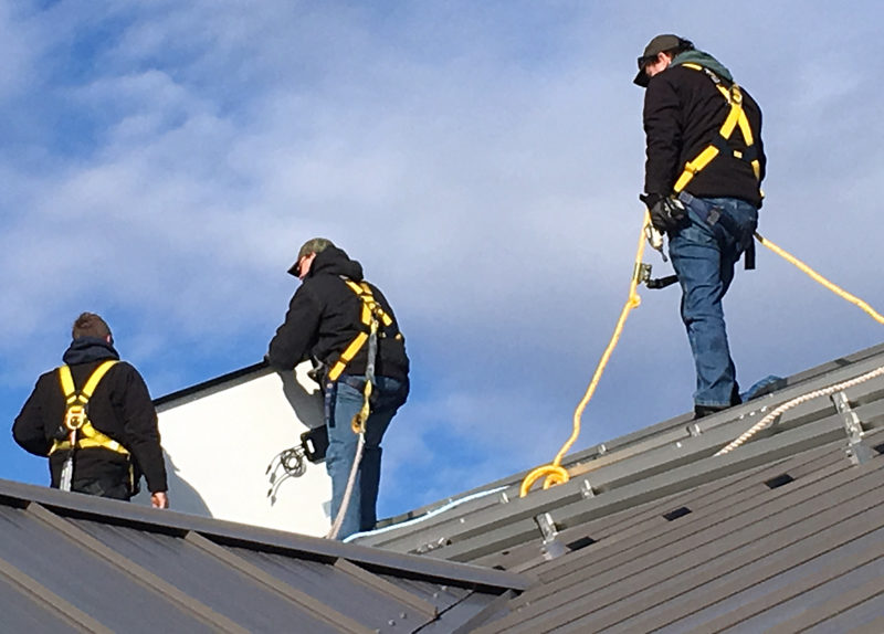 Workers install a solar array on the roof of the Whitefield municipal fire station in mid-December. (Photo courtesy Richard Simon)