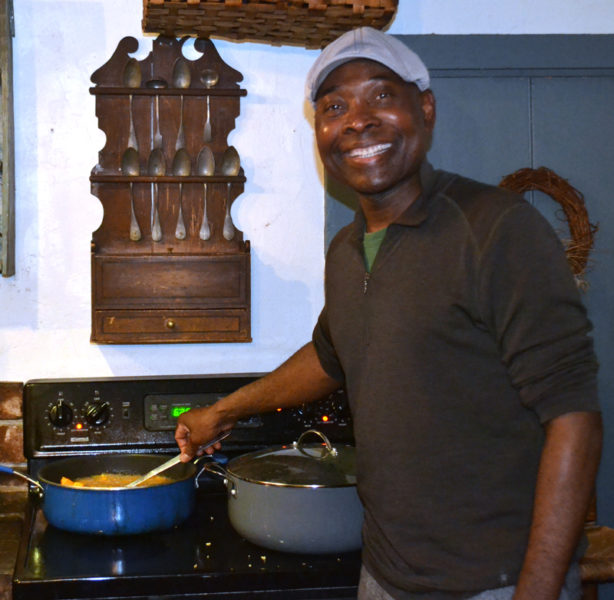 Messan Jordan Benissan prepares sweet potatoes, cooked in traditional Togolese fashion, for a community dinner at Patricia Stauble Antiques in Wiscasset on Thursday, Dec. 8. (Abigail Adams photo)