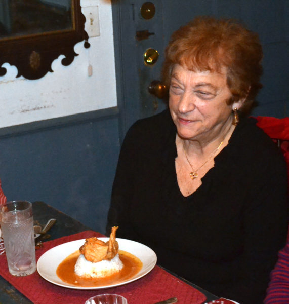 Patricia Stauble enjoys a traditional Togolese entree during a dinner she hosted Thursday, Dec. 8 to introduce the community to Messan Jordan Benissan's cuisine. (Abigail Adams photo)