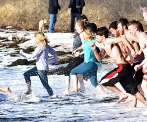 Participants in the eighth annual Pemaquid Polar Bear Dip race into the water at Pemaquid Beach Park on New Year's Day. The event raises funds for the Lincoln County Animal Shelter. (Photo courtesy Sherrie Tucker/sherrietucker.com)