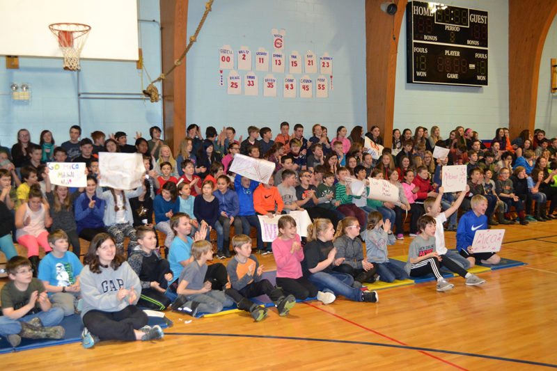 Students at Great Salt Bay Community School wave signs in support of their friends and classmates during the GSB spelling bee Thursday, Jan. 26. (Maia Zewert photo)