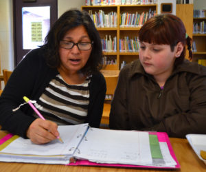 Lissette Griffin (left) works with Great Salt Bay Community School fifth-grader Catherine Shaw on Monday, Jan. 29. Every Monday and Tuesday, Griffin teaches Spanish to groups of students in the GSB library during their lunch and recess hour. (Maia Zewert photo)