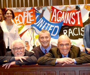 From left: Martin Luther King Jr. Day event organizers and speakers Lindy Gifford, Rev. Allison Smith, Rev. Mike Stevens, Rev. Mark Hamilton, Reza Jalali, and Rev. Erika Hewitt gather around the People United Against Racism banner at The Second Congregational Church in Newcastle on Monday, Jan. 16. (Abigail Adams photo)