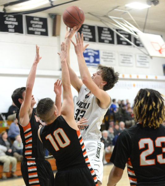 Cody Tozier shoots over a pair of Winslow defenders. (Paula Roberts photo)