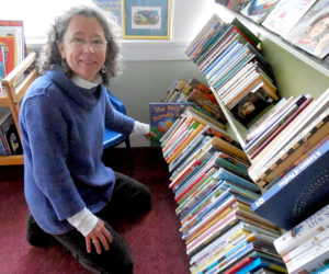 Rosie Bensen, co-manager of the Skidompha Secondhand Book Shop in Damariscotta, shelves books in the children's section of the newly relocated book shop, which is set to open Wednesday, Feb. 1. (Christine LaPado-Breglia photo)